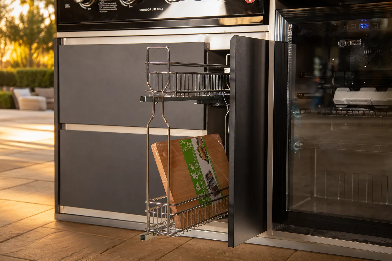 Luxury outdoor kitchen beverage station at golden hour with pull-out storage and refrigerator